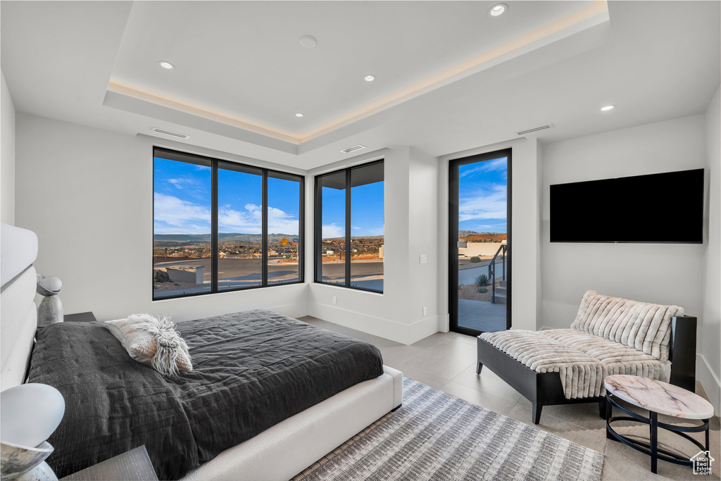 Bedroom with access to exterior, a raised ceiling, and recessed lighting