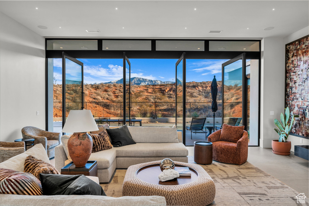 Living area with floor to ceiling windows and a mountain view