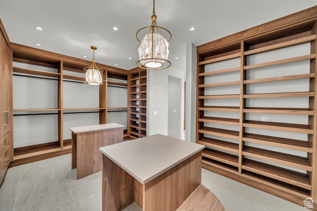 Walk in closet with a chandelier and light tile patterned flooring