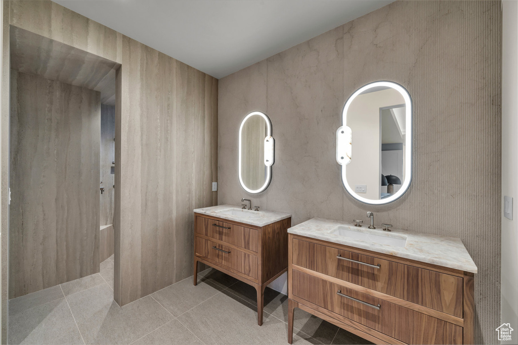 Full bathroom featuring two vanities and tile patterned flooring