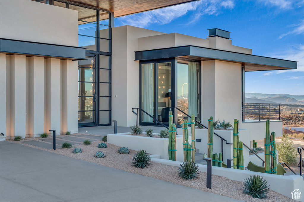 View of exterior entry with stucco siding and a mountain view