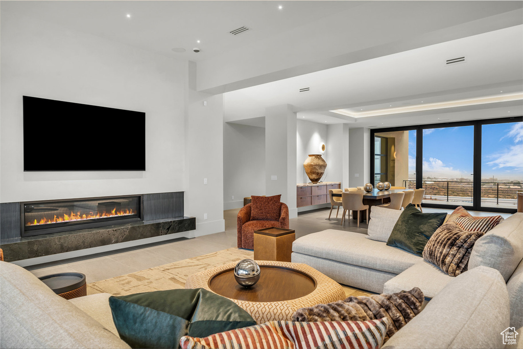Living room with a high end fireplace, recessed lighting, and wood finished floors