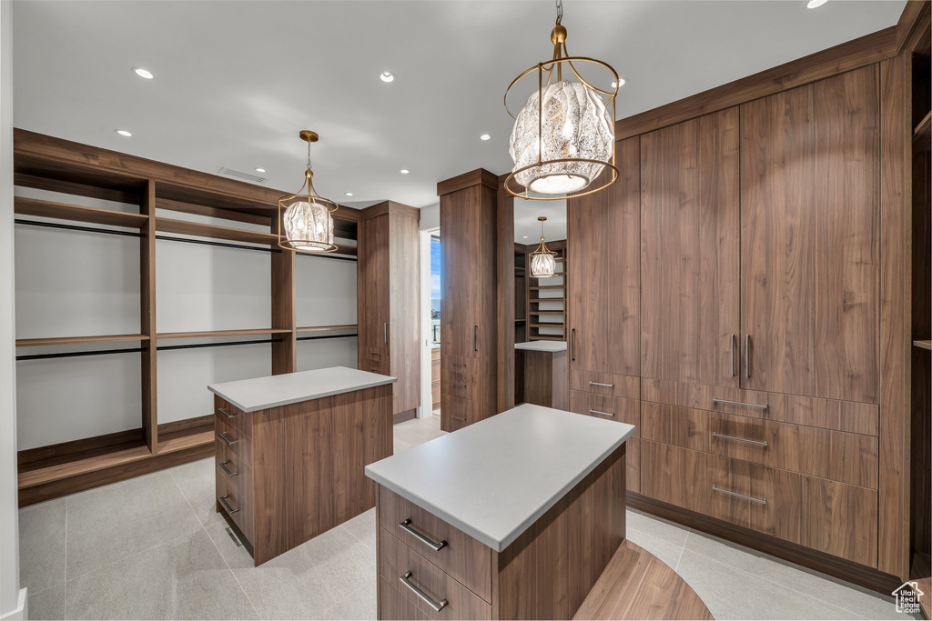 Walk in closet featuring a chandelier and light tile patterned floors