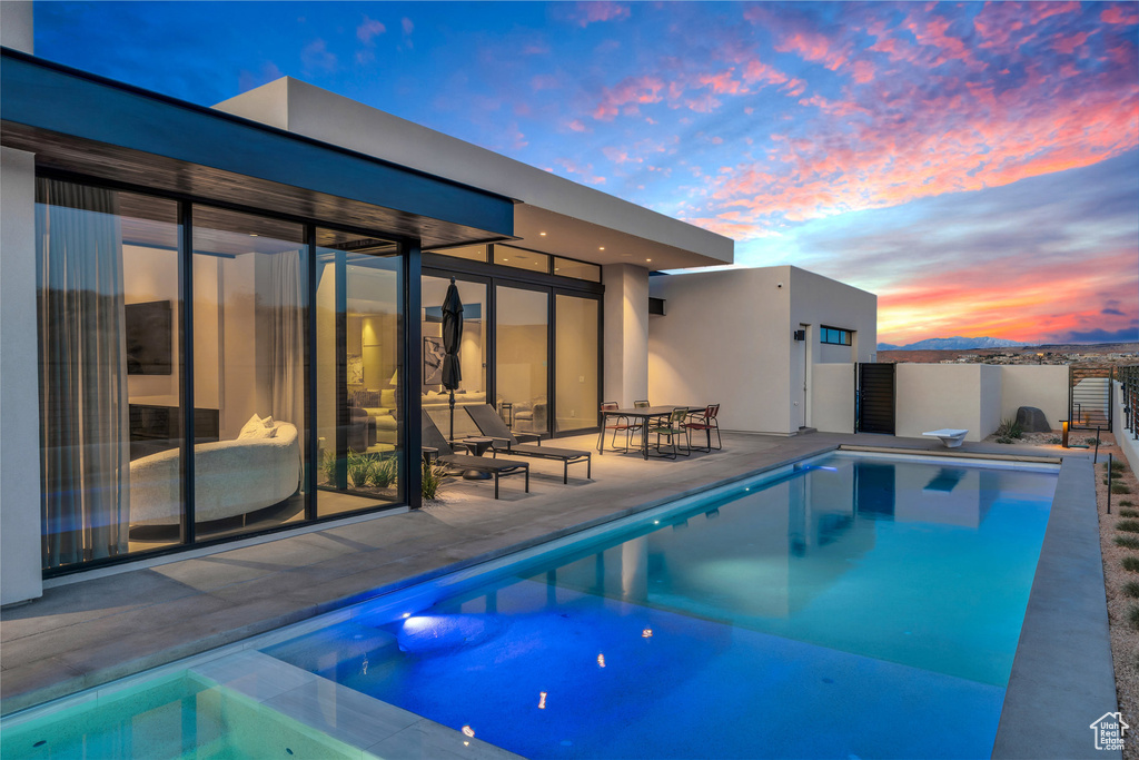 View of pool with a patio and a diving board