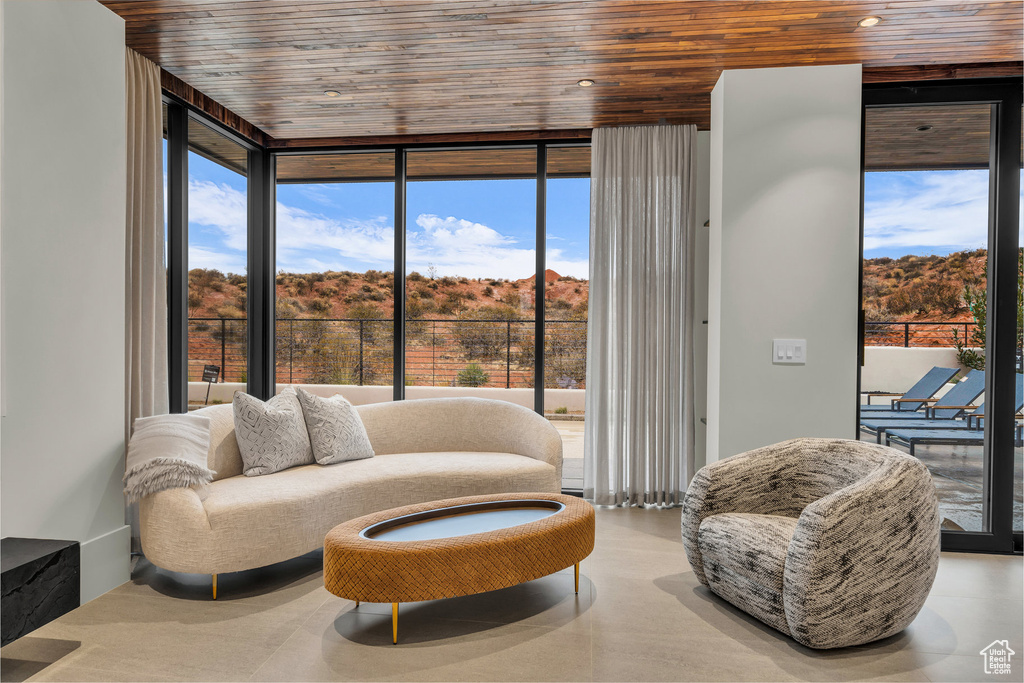 Sitting room featuring wood ceiling, a wall of windows, and plenty of natural light