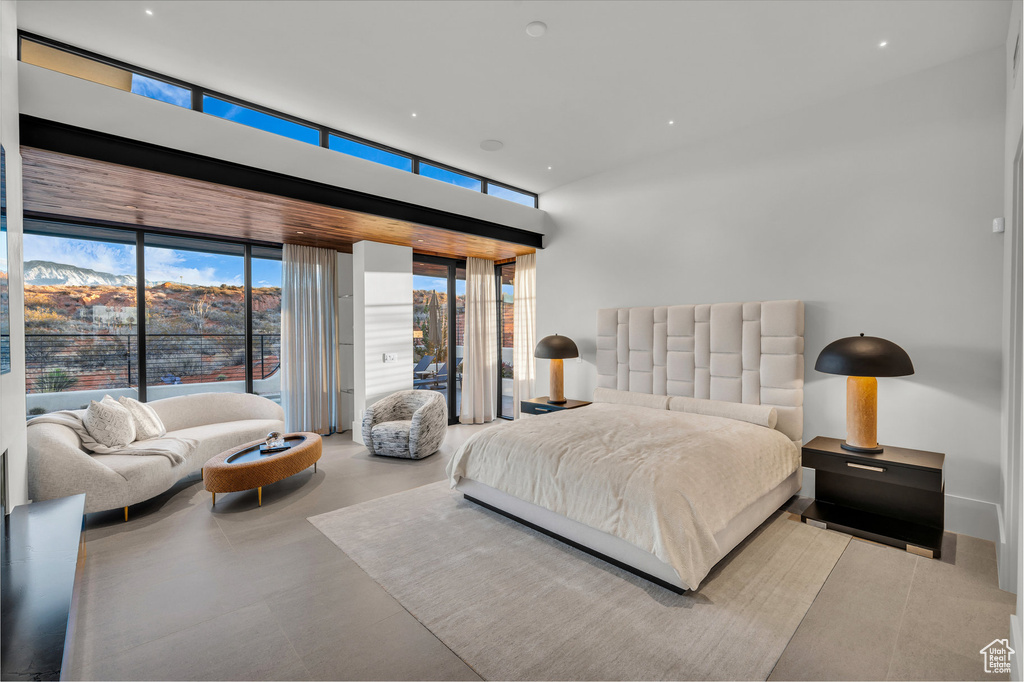 Bedroom featuring floor to ceiling windows and concrete flooring