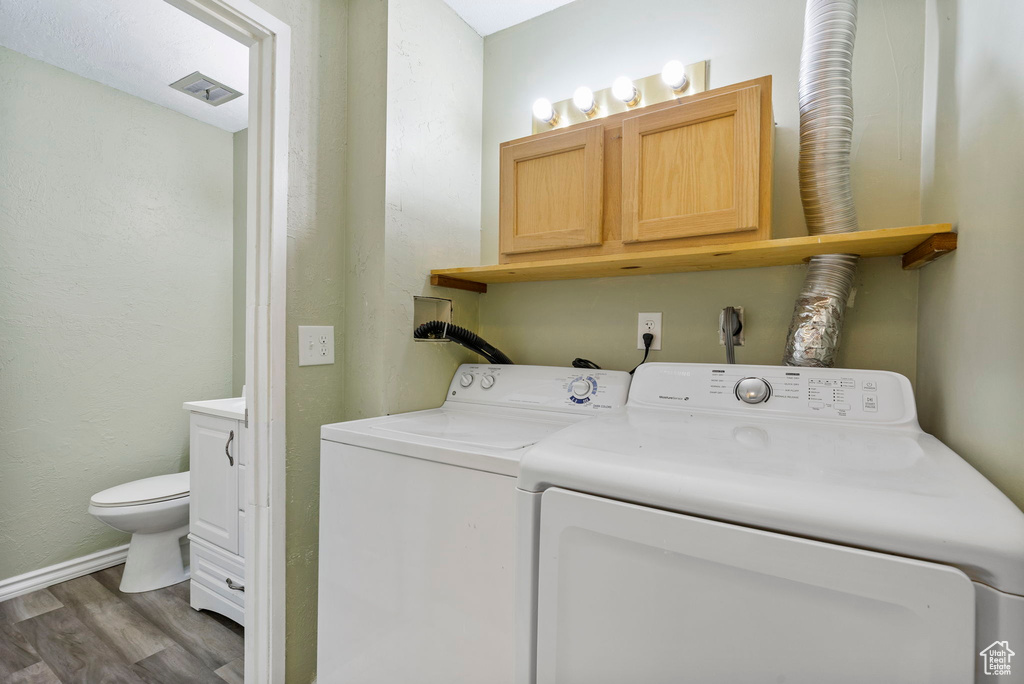 Laundry room featuring cabinets, independent washer and dryer, and dark hardwood / wood-style floors