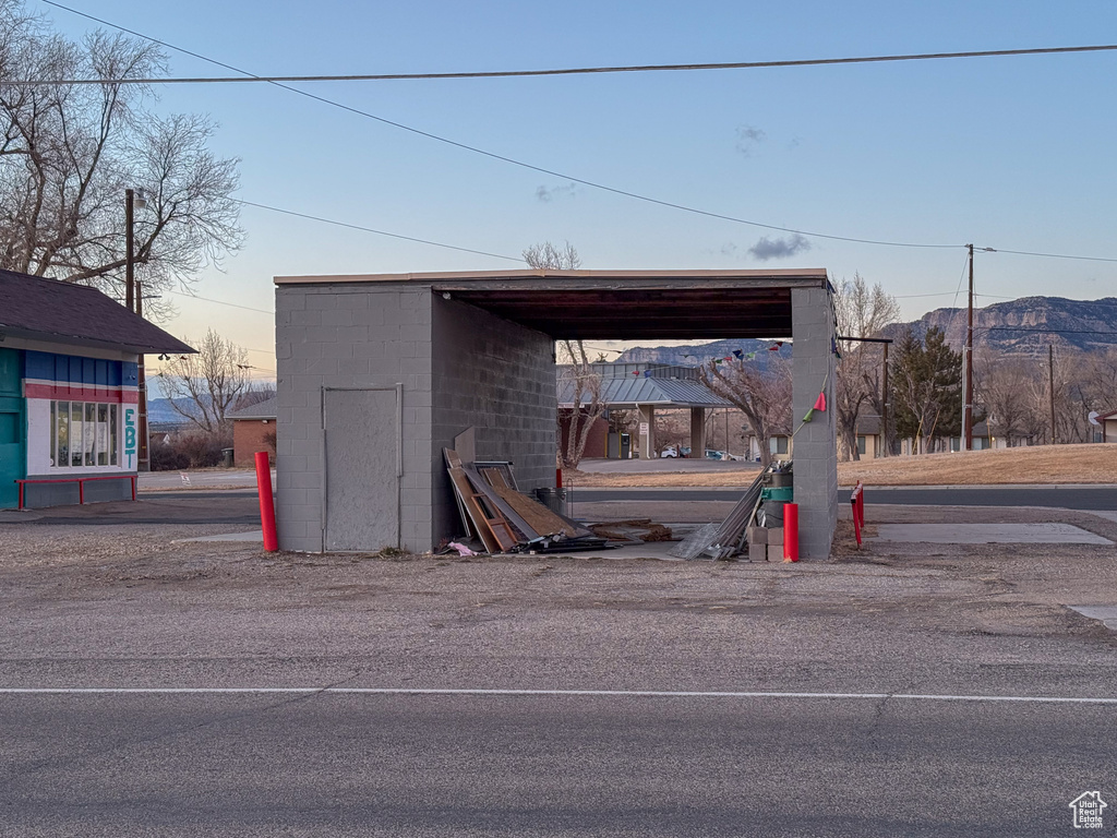 Outdoor structure at dusk with a mountain view and a carport