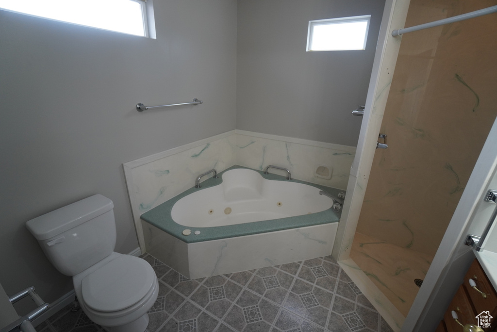 Full bathroom featuring plus walk in shower, toilet, tile patterned flooring, and a wealth of natural light