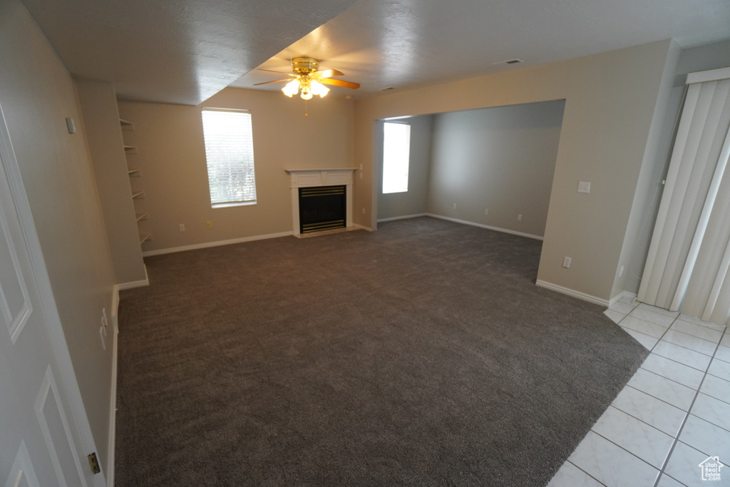 Unfurnished living room with ceiling fan and light tile patterned floors