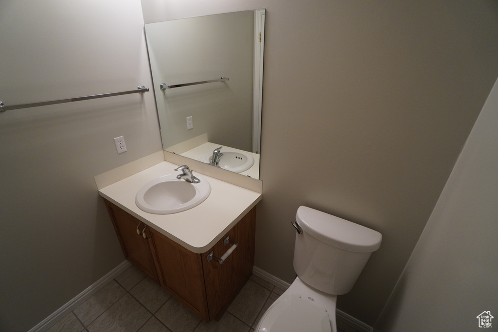 Bathroom featuring vanity, tile patterned floors, and toilet