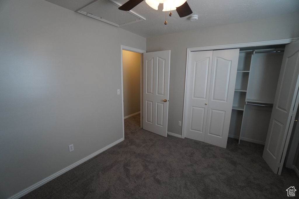 Unfurnished bedroom featuring dark colored carpet, ceiling fan, and a closet