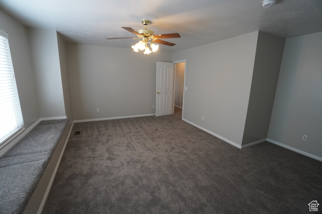 Carpeted empty room with ceiling fan