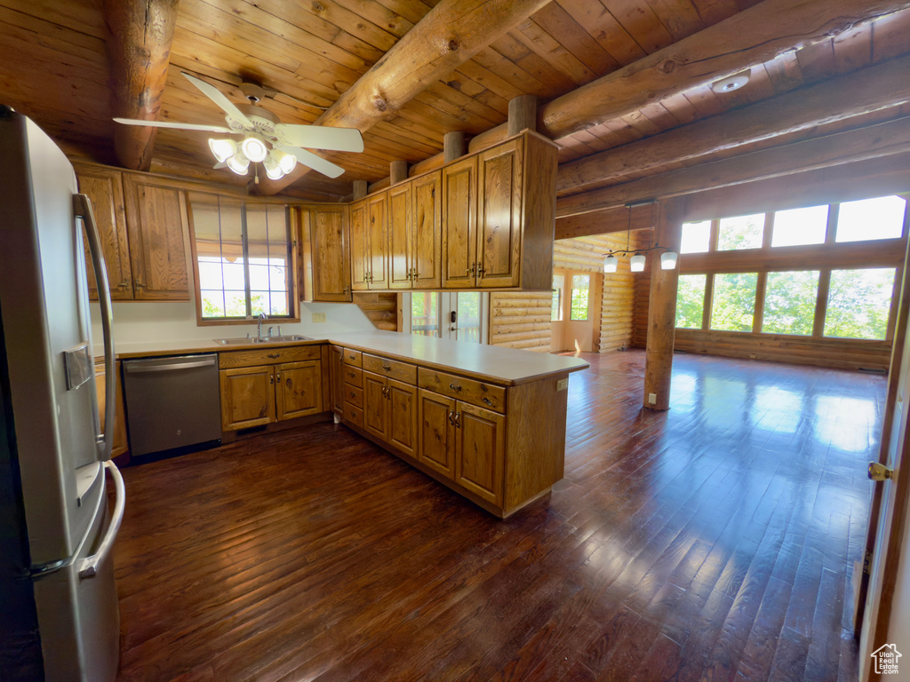 Kitchen featuring appliances with stainless steel finishes, wooden ceiling with exposed beams, a ceiling fan, plenty of natural light, and dark wood finished floors