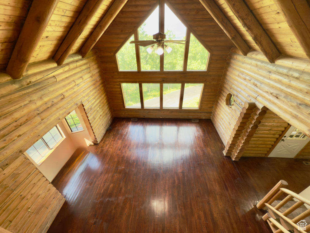 Unfurnished living room with log walls, a ceiling fan, wooden ceiling, and hardwood / wood-style floors