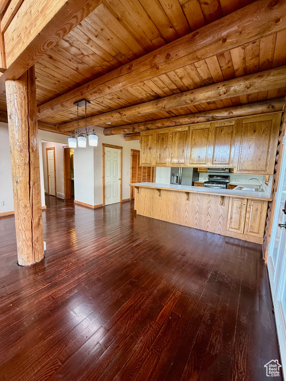Unfurnished living room featuring dark wood-style floors, wooden ceiling with exposed beams, baseboards, and a sink
