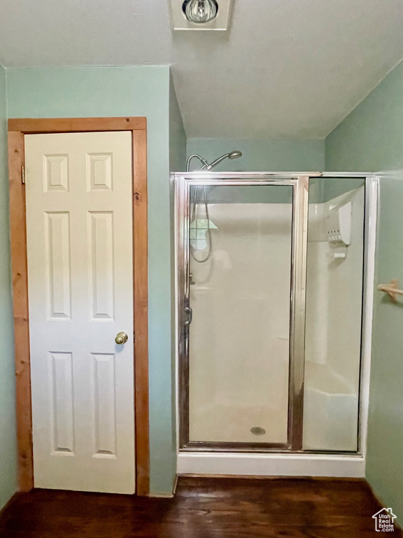 Full bathroom with wood finished floors and a stall shower