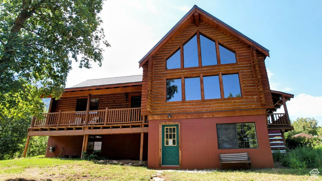 Back of house with log exterior, a deck, and stairway