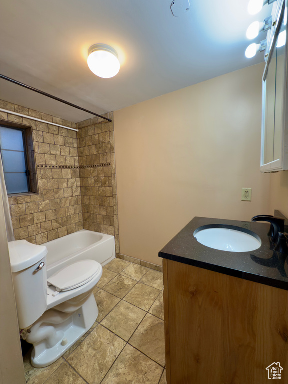 Full bathroom with toilet, vanity, tile patterned floors, shower / bathtub combination, and baseboards