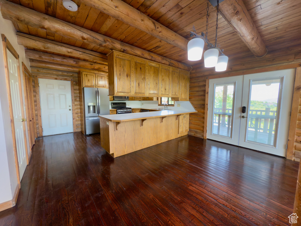 Kitchen with appliances with stainless steel finishes, french doors, a peninsula, light countertops, and dark wood finished floors