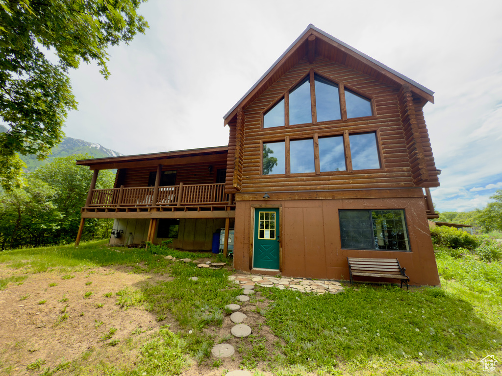 Rear view of house featuring log exterior, a deck, and board and batten siding