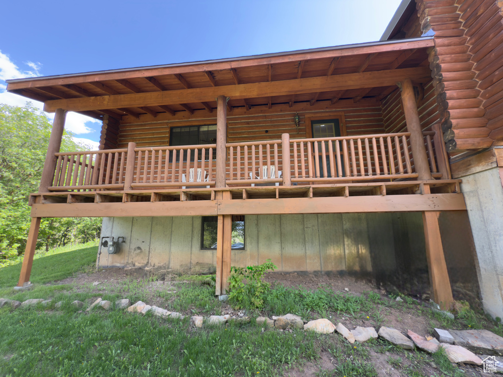 Back of property featuring log exterior and a deck