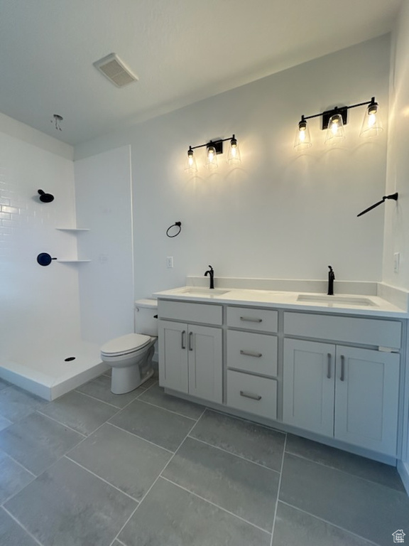 Full bath featuring toilet, a shower, tile patterned flooring, and double vanity