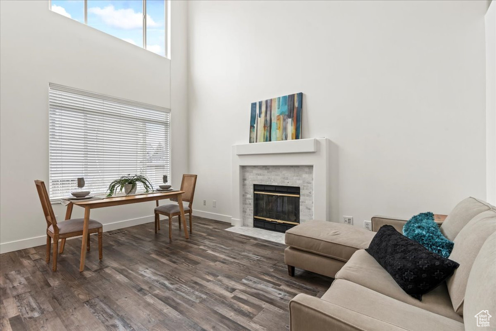 Living room with a high ceiling and dark hardwood / wood-style flooring
