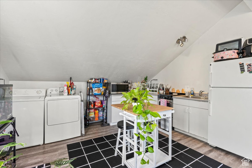 Laundry area with wood-type flooring, separate washer and dryer, and sink