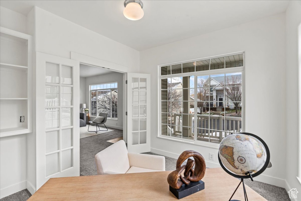 Carpeted dining space featuring french doors