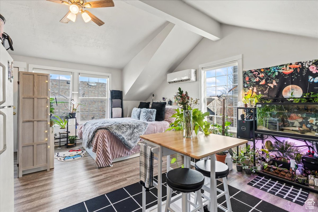 Bedroom featuring multiple windows, wood-type flooring, and a wall mounted AC