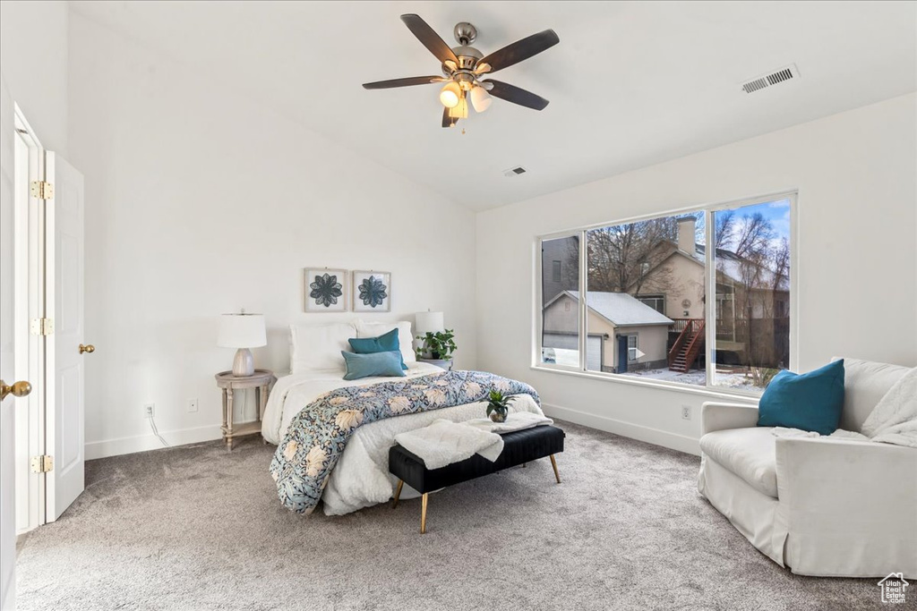 Bedroom with lofted ceiling, ceiling fan, and carpet
