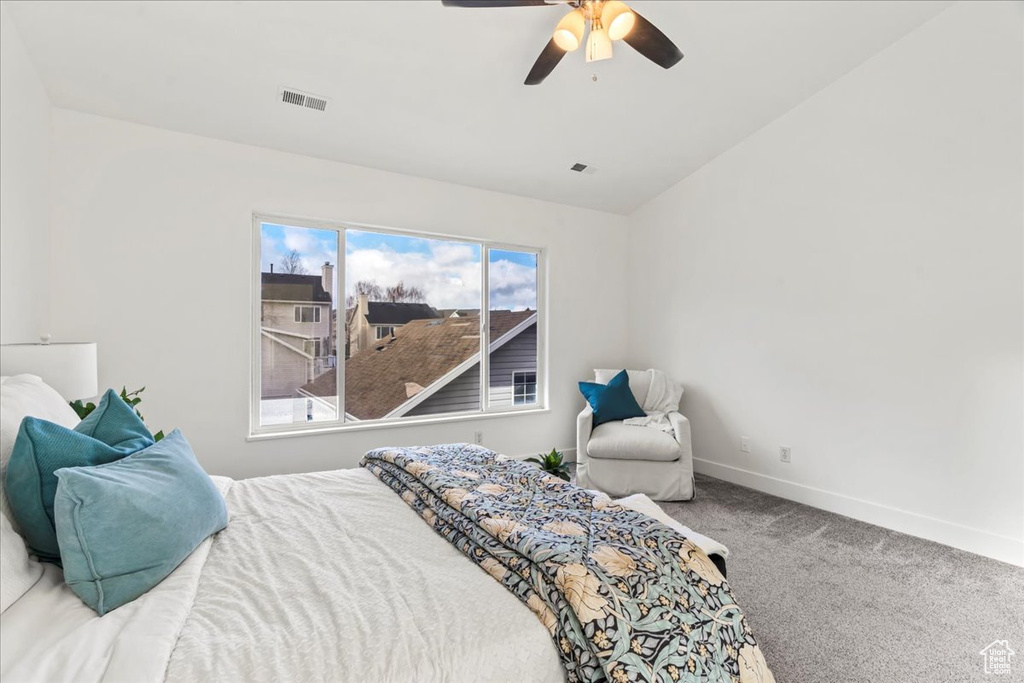 Bedroom with ceiling fan, lofted ceiling, and carpet
