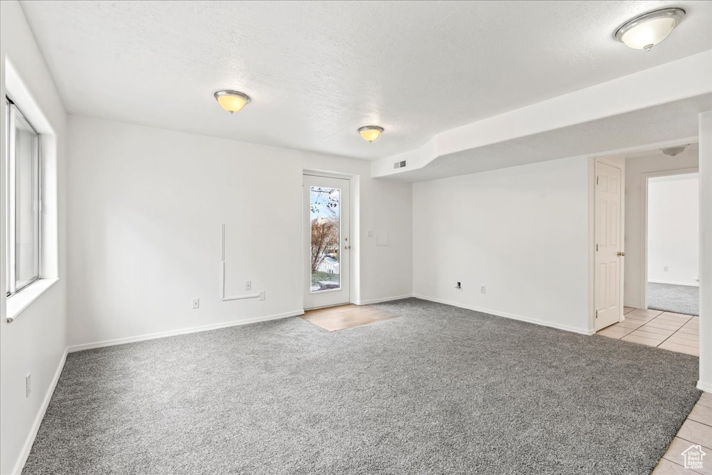 Carpeted empty room featuring a textured ceiling