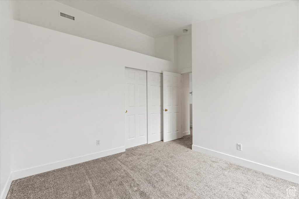 Unfurnished bedroom featuring a closet and carpet flooring