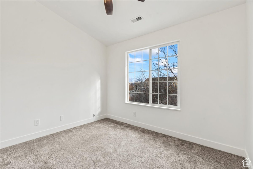 Empty room with carpet floors and ceiling fan