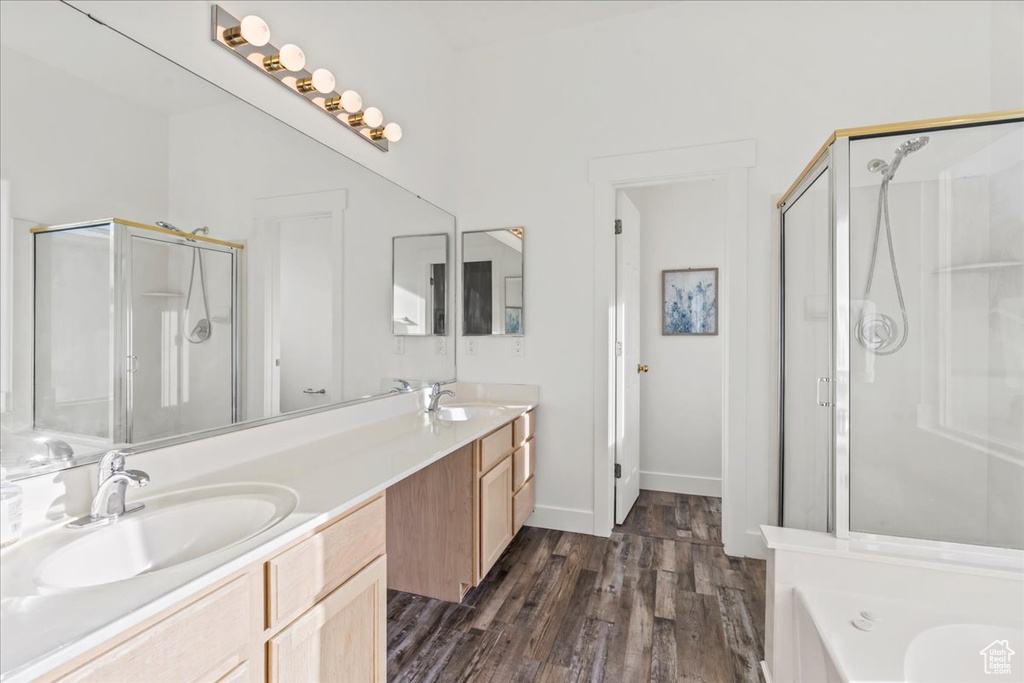 Bathroom with vanity, independent shower and bath, and hardwood / wood-style floors