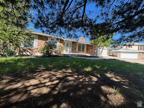 Single story home featuring a chimney and brick siding