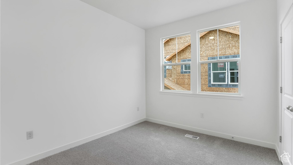Carpeted empty room with baseboards