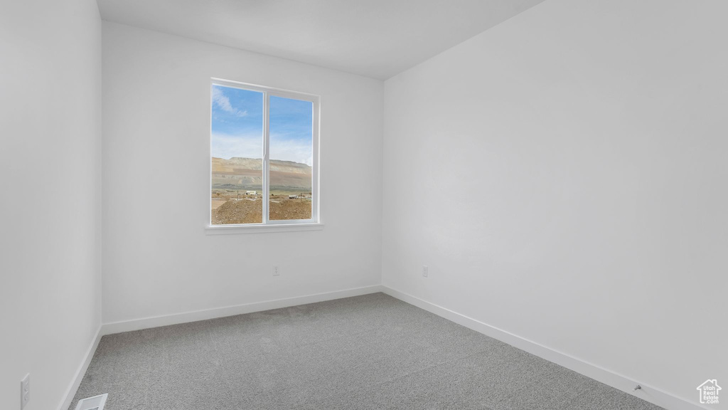Empty room with carpet flooring and baseboards