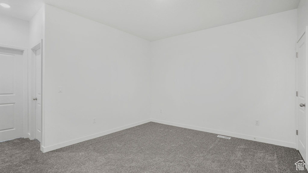 Carpeted spare room featuring baseboards