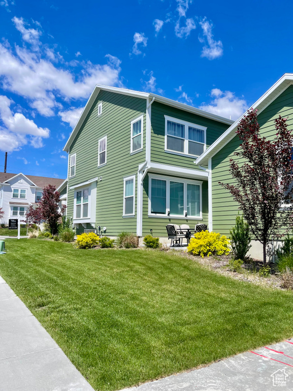 View of property exterior featuring a yard and a patio area