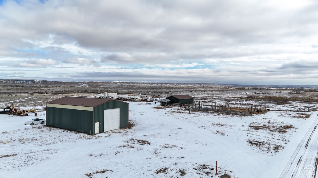 Yard covered in snow with a garage and an outdoor structure