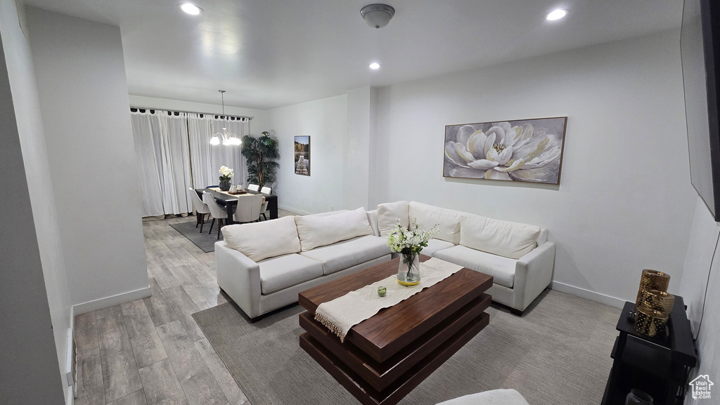 Living room featuring light hardwood / wood-style flooring and a notable chandelier