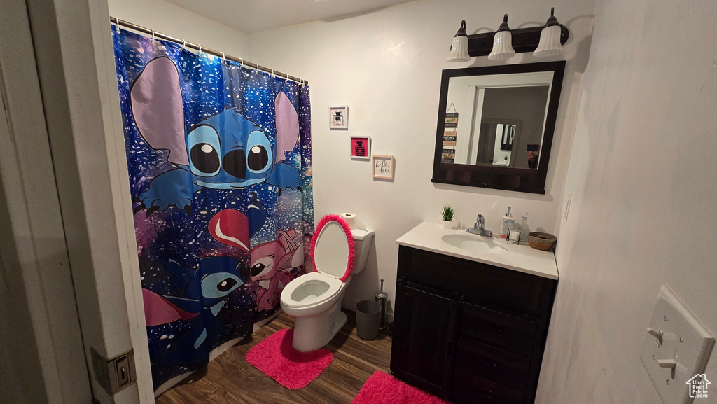 Bathroom featuring hardwood / wood-style flooring, vanity, and toilet