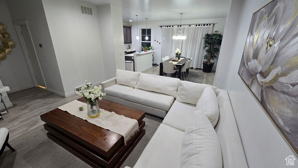 Living room with dark hardwood / wood-style floors and a chandelier