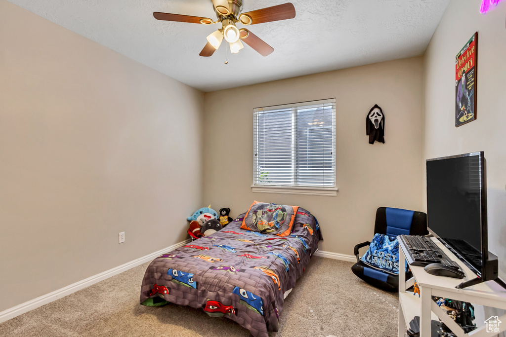 Bedroom featuring light carpet, a textured ceiling, and ceiling fan