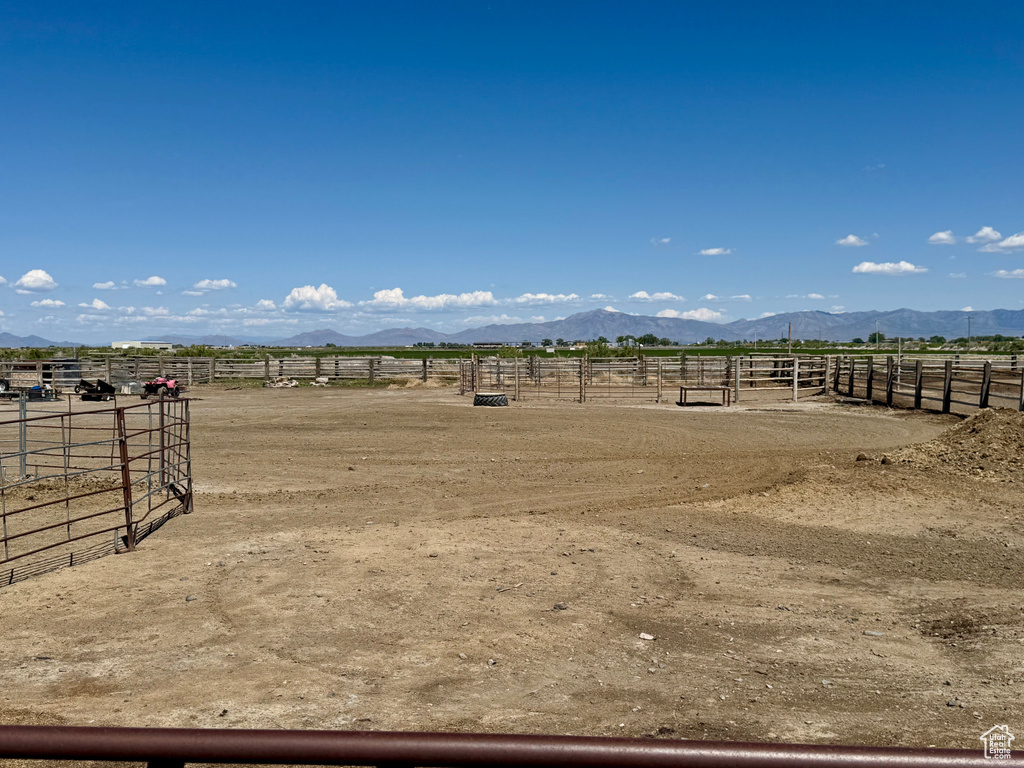 View of yard featuring an enclosed riding area, a rural view, an exterior structure, and a mountain view