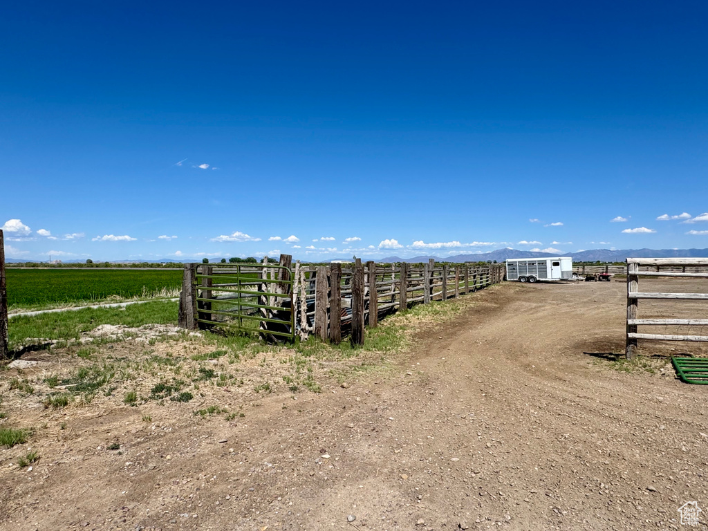 View of dirt / gravel driveway with a view of countryside and a gated entry