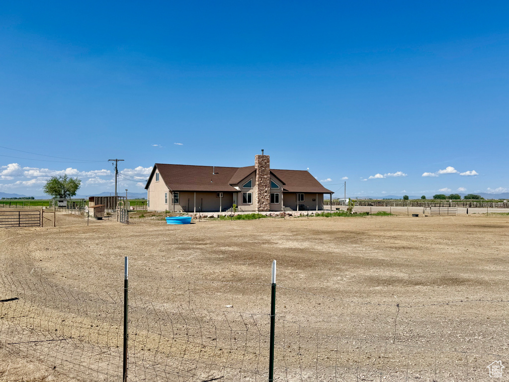 Rear view of property with a chimney and a view of rural / pastoral area